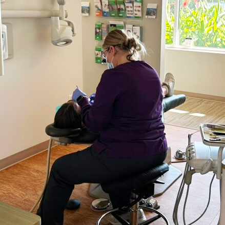 dental assistant performing dental exam on patient