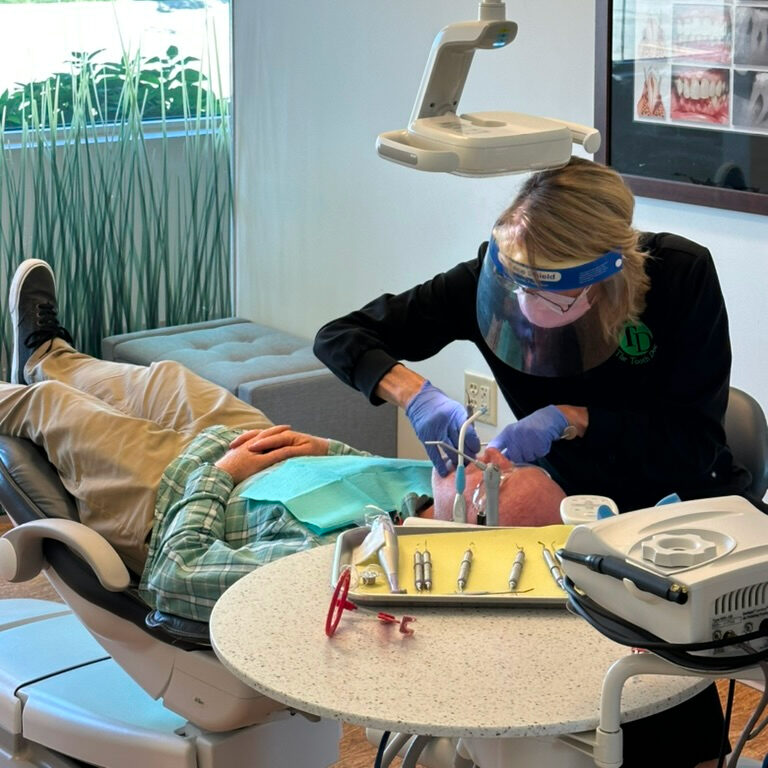 dental assistant performing dental exam on patient