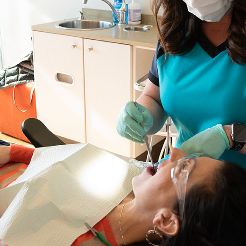 dental assistant performing dental exam on patient